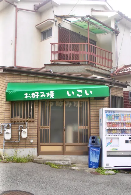 緑の日よけと格子戸の、昔ながらのお好み焼き屋