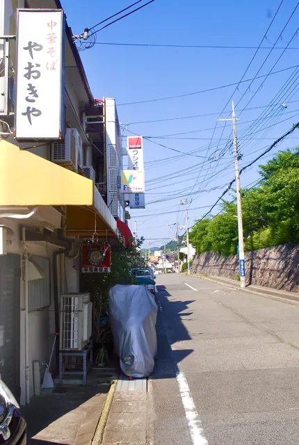 中華そばの縦長の看板と、黄色い日よけのある通り