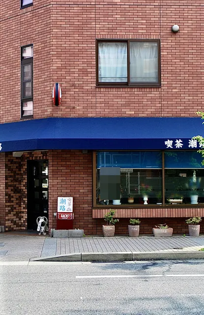 青い日よけとレンガの壁の、角の喫茶店