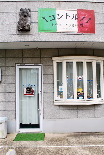 「コントルノ」の看板と、白い出窓のある店の入口