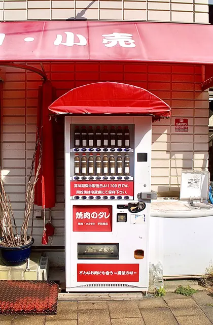 赤いひさしの下の、焼肉のタレが並ぶ珍しい自動販売機