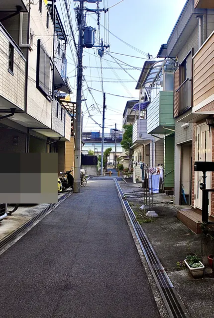 車の止まる家々のあいだを、奥へまっすぐ続く細い道