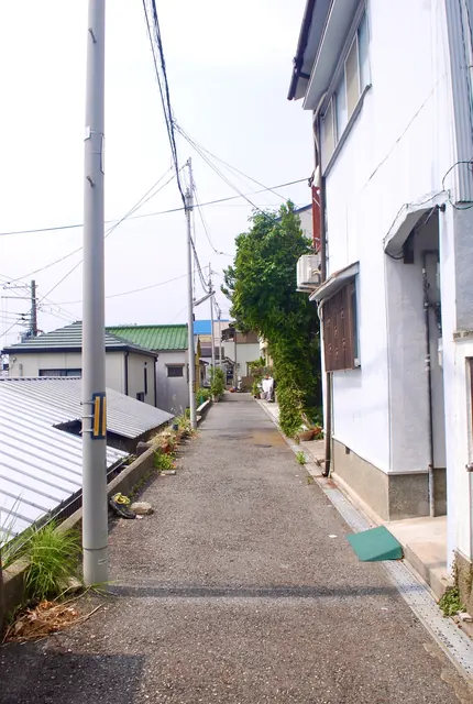 トタン屋根と家々のあいだを、奥へまっすぐ続く細い道