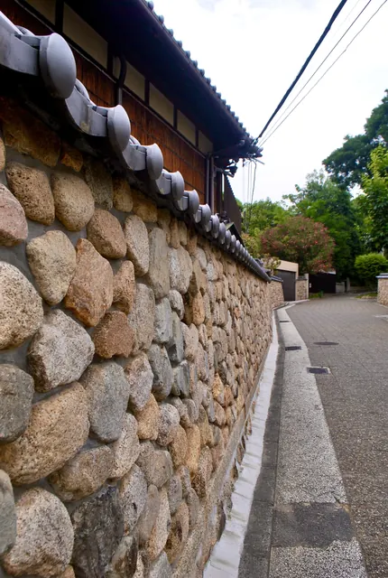 丸い石を積み上げた石垣の塀が、ゆるやかに奥へ続く道