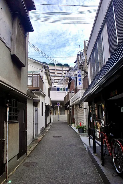 自転車が止まる、看板の下がった細い路地