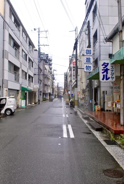 縦長のタオル屋の看板と、奥へ続く下町の通り