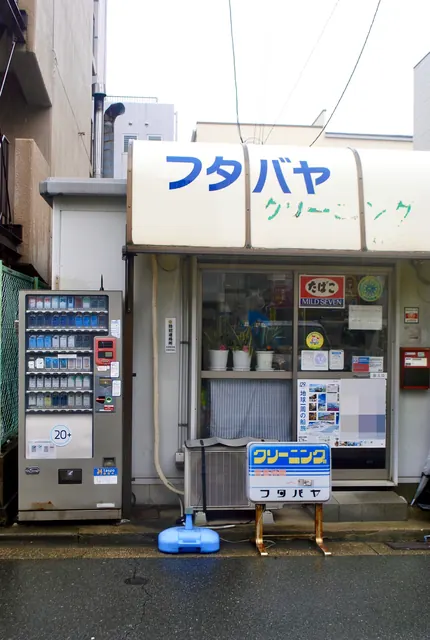 たばこの自動販売機と、古いクリーニング店の店先