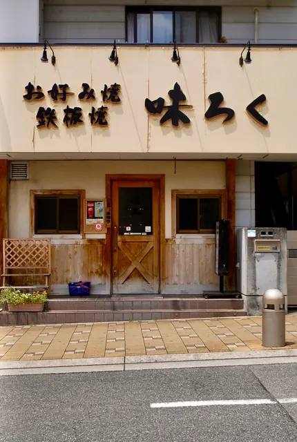 木の扉と格子の窓がある、お好み焼・鉄板焼の店