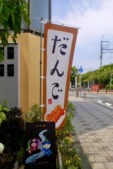 「だんご」ののぼりと手描きの看板、花の咲く店先