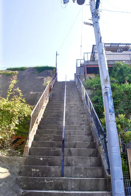 手すりのついた長い石段が、空へ向かってまっすぐ上る風景
