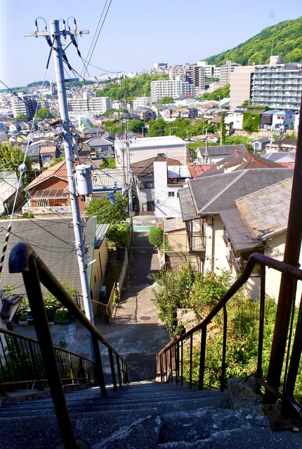 石段の上から、町並みとその奥の山並みを見渡す風景