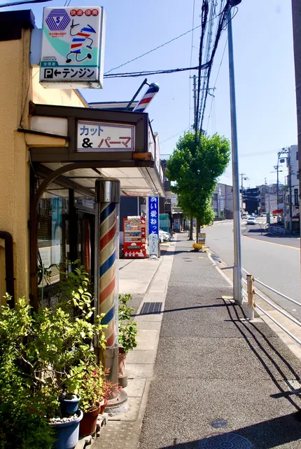 回るサインポールの理容店の前を、まっすぐ続く歩道