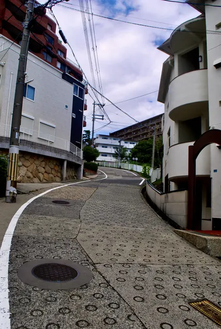 丸い滑り止めの模様の坂が、建物のあいだを大きくカーブしていく風景