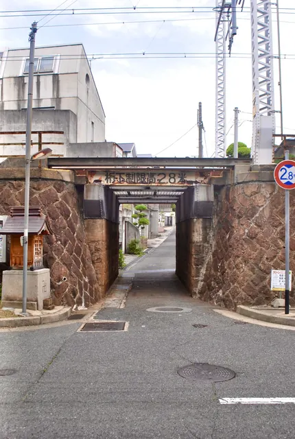 石積みの古いガードの脇に、小さなお社がある風景