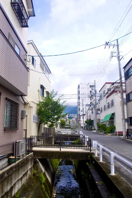 家々のあいだを流れる小さな川と、川沿いに続く道