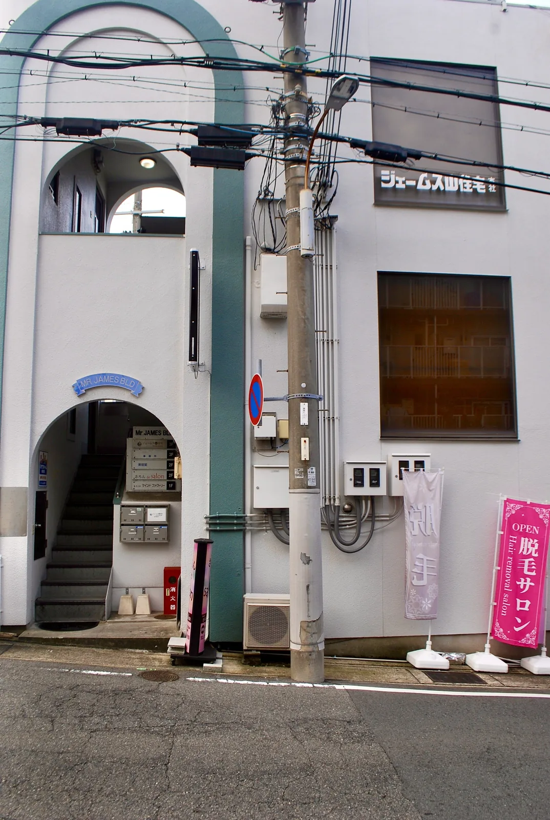 アーチ形の入口と、ジェームス山住宅の看板のある白いビル