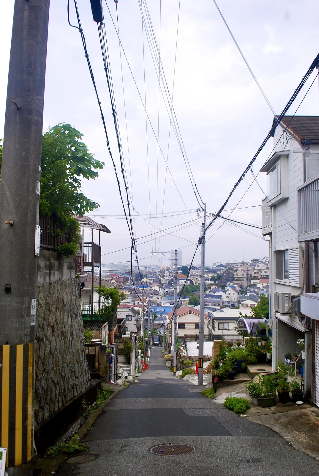 電線の下を、遠くの家並みと海の方へ下っていく坂道