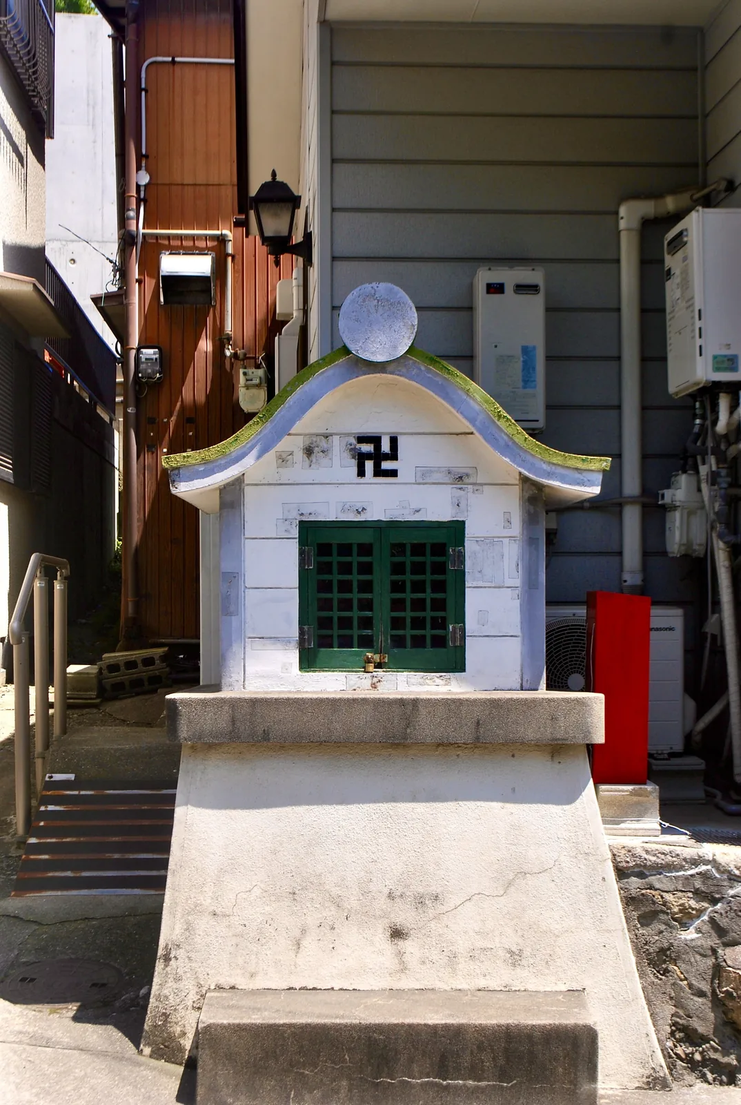 建物のあいだにたたずむ、白い小さなお堂