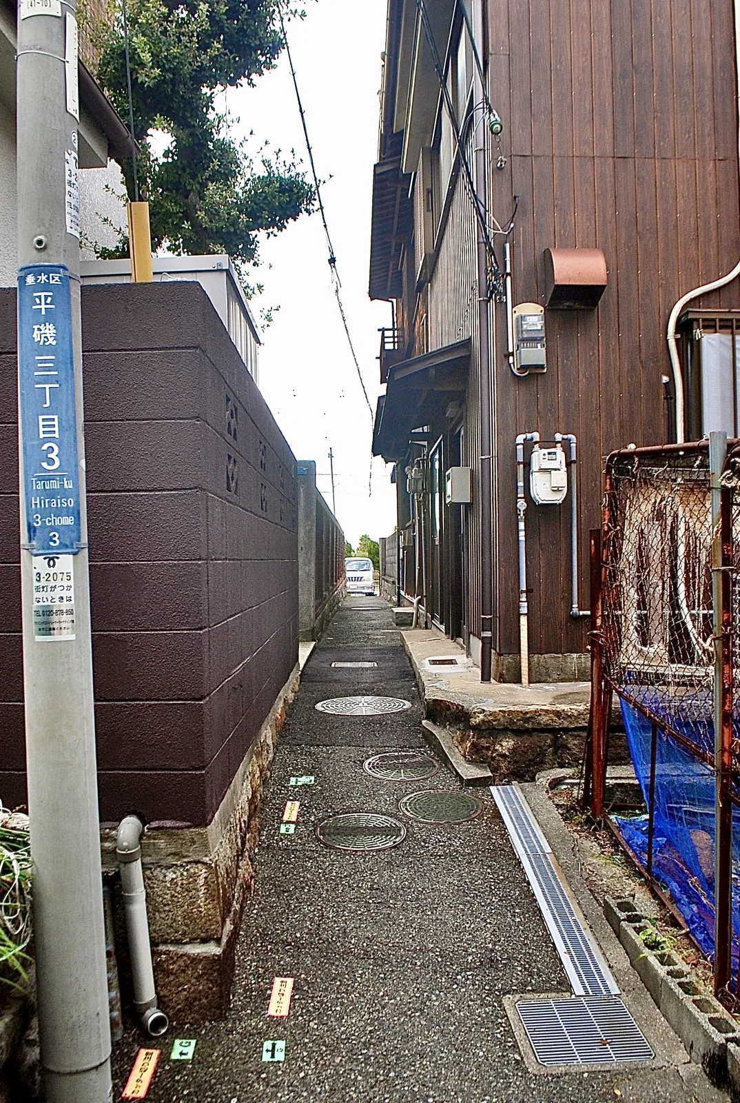町名表示のある電柱の先に、家々のあいだをまっすぐ続く路地