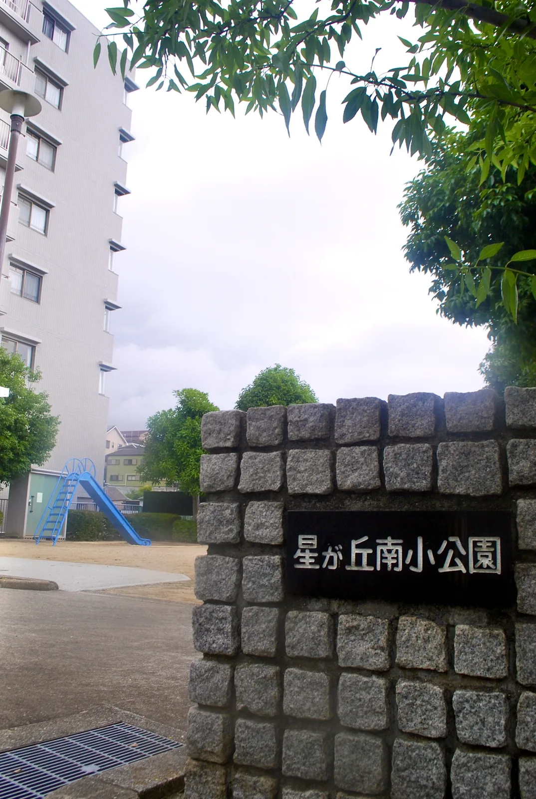 「星が丘南小公園」と書かれた石の門と、すべり台のある公園