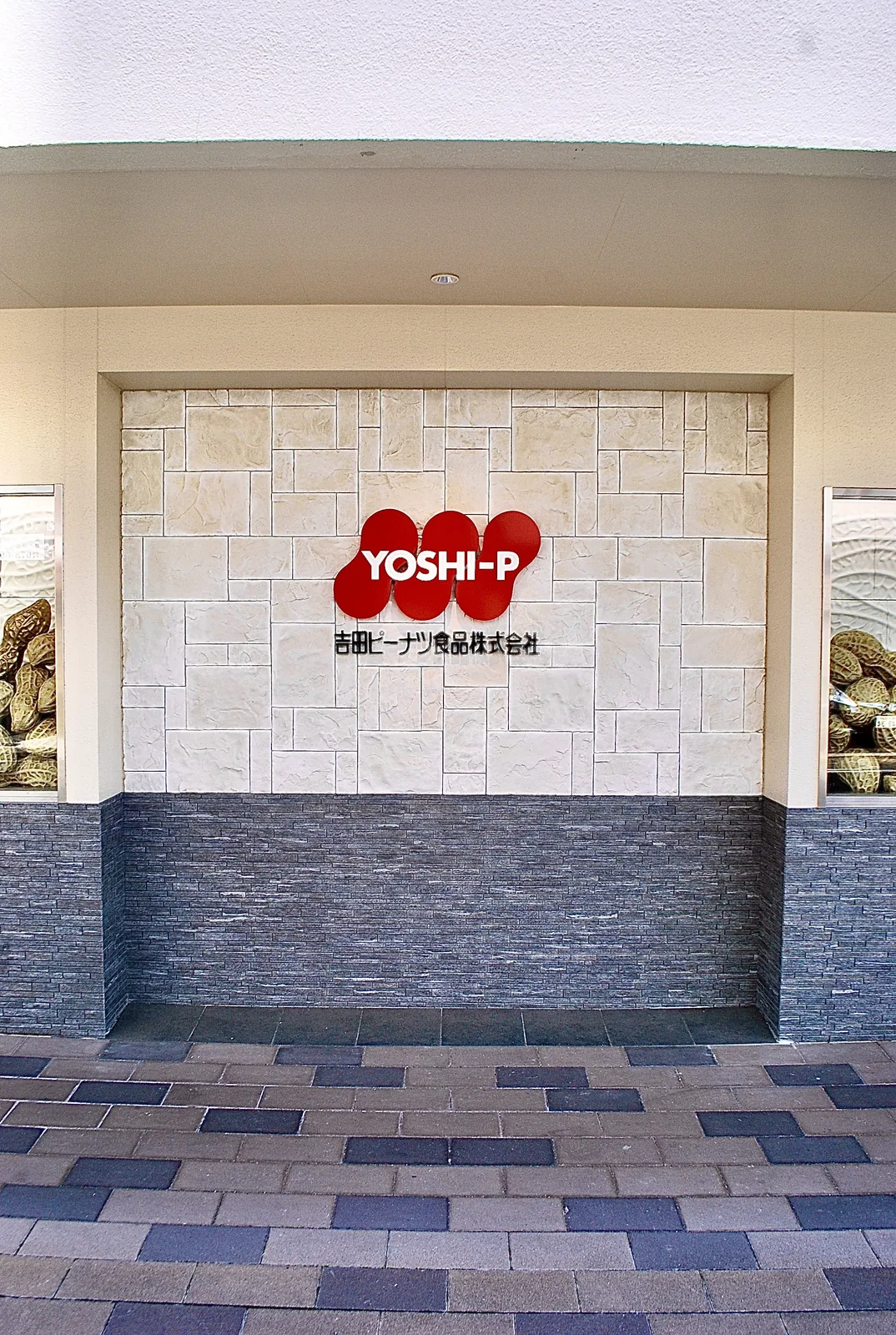 石張りの壁に赤い「YOSHI-P」のマークと、殻つきピーナツの飾り
