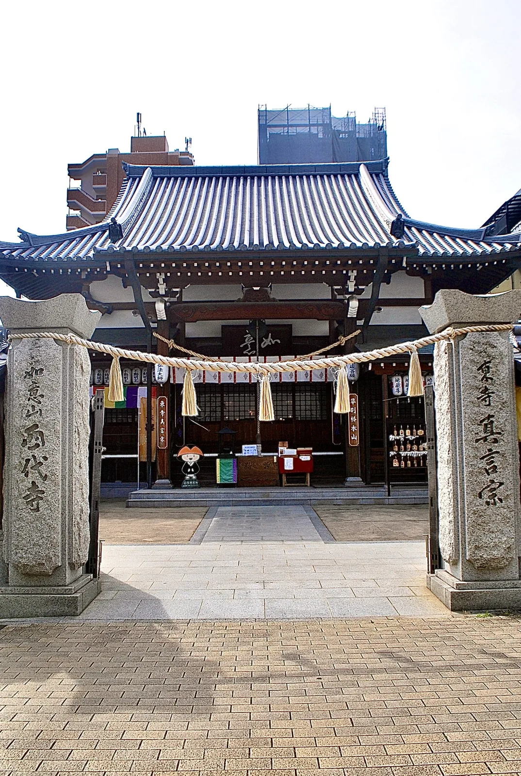 「如意山 西代寺」と刻まれた石の門柱と、しめ縄の向こうのお堂