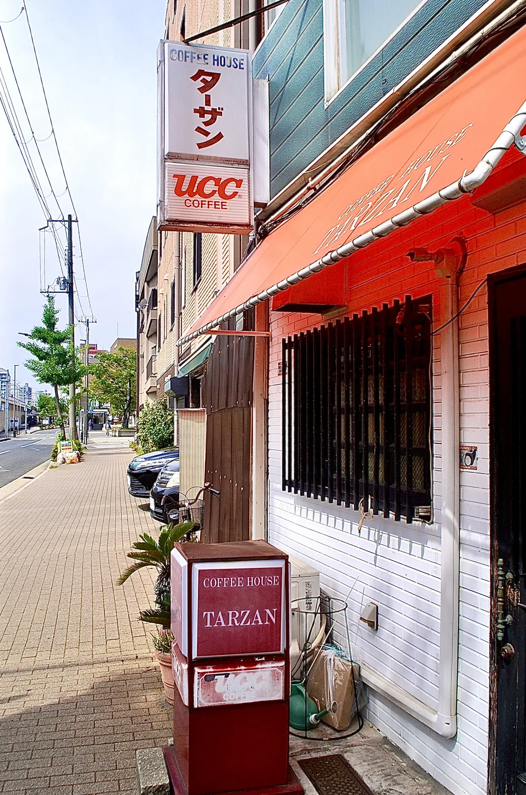 「COFFEE HOUSE ターザン」の看板と、赤い日よけの喫茶店