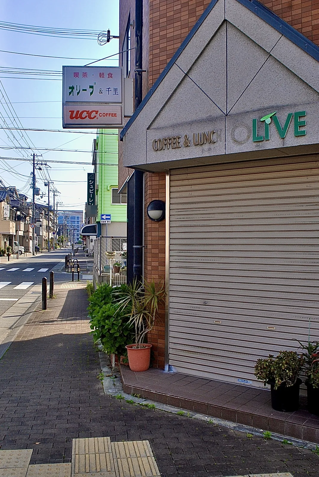 「COFFEE & LUNCH LIVE」の看板と、交差点の見える歩道