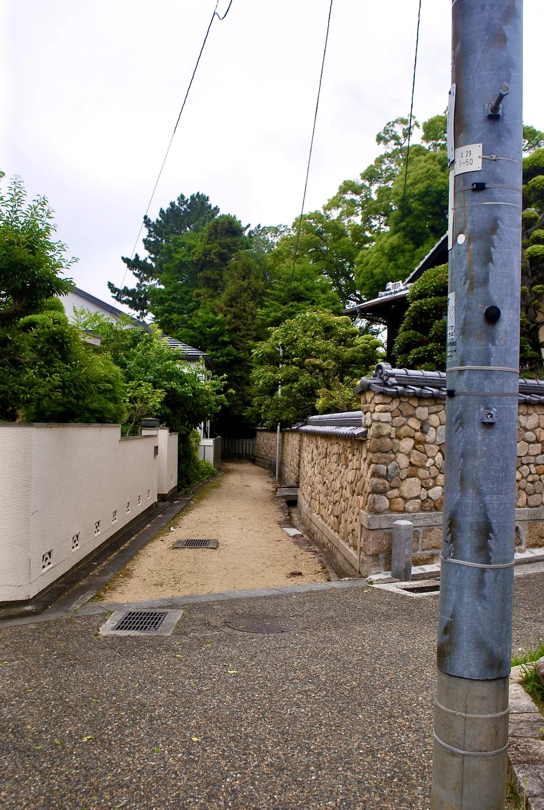 白い塀と石垣の屋敷のあいだを奥へ続く、砂利の小道
