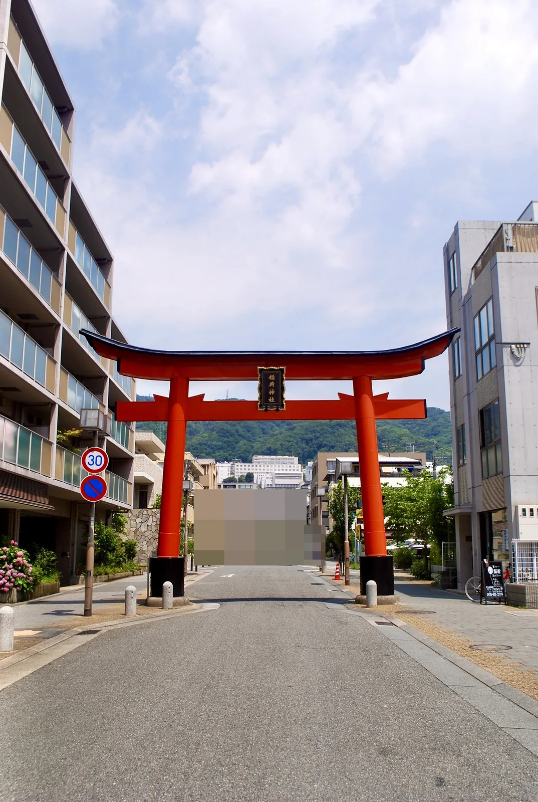 山を背に、道の真ん中にそびえる朱色の大きな鳥居