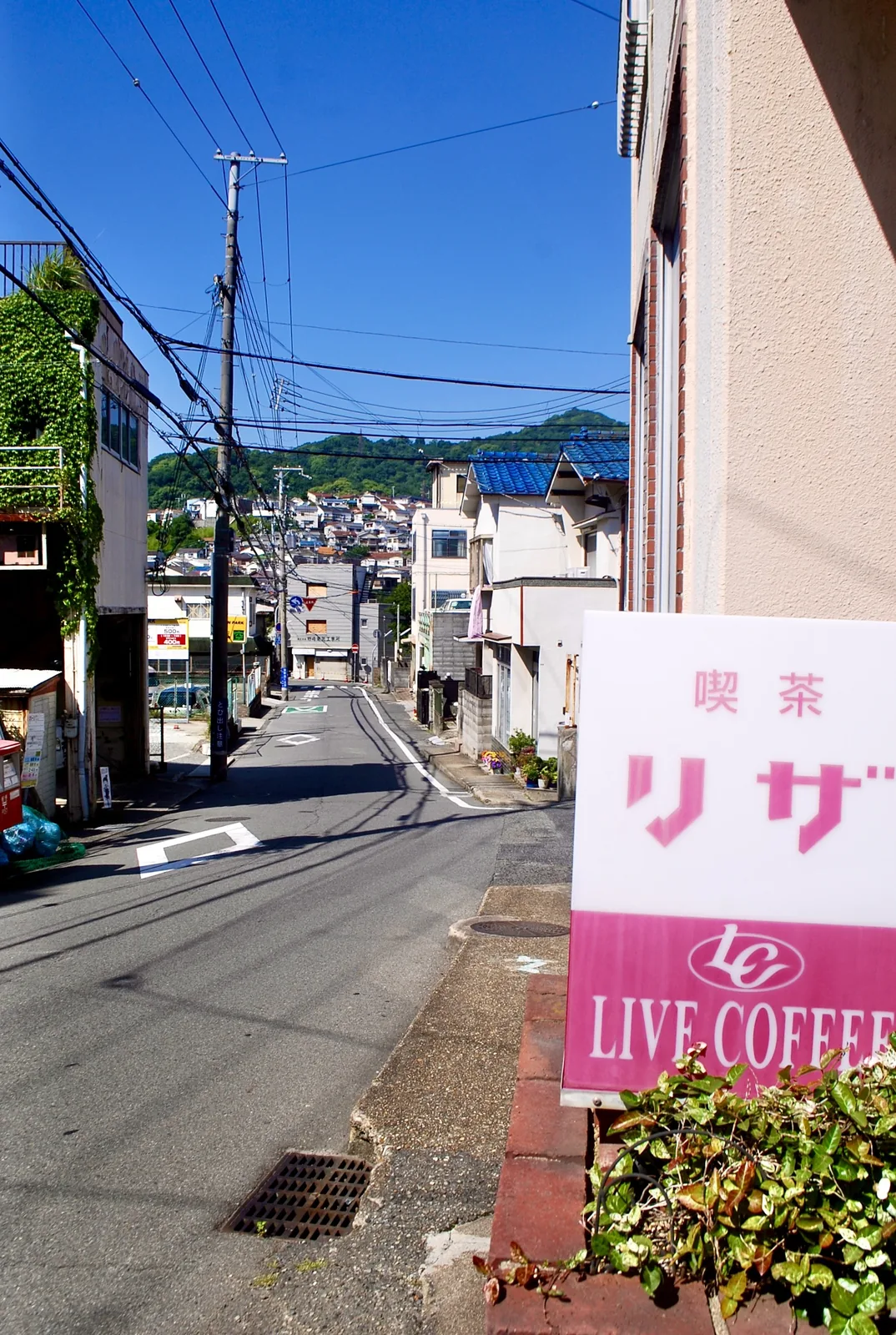 古い社名の看板が並ぶ、白い建物の壁