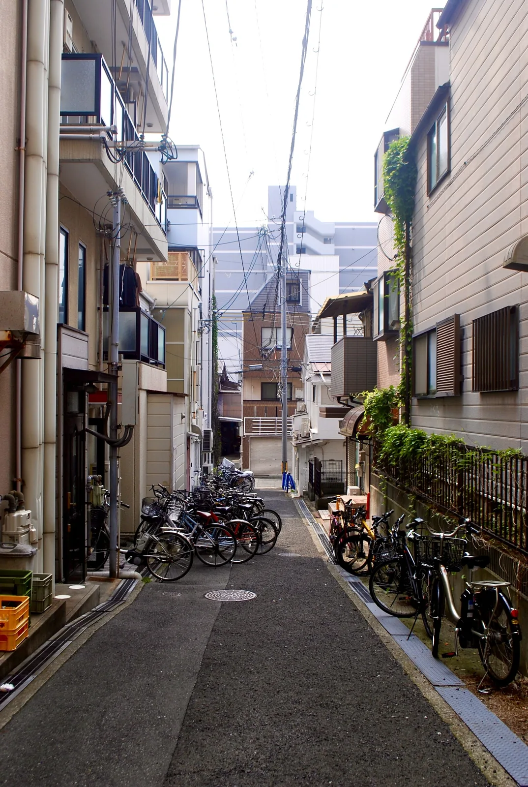 自転車がずらりと並ぶ、家々のあいだの細い路地