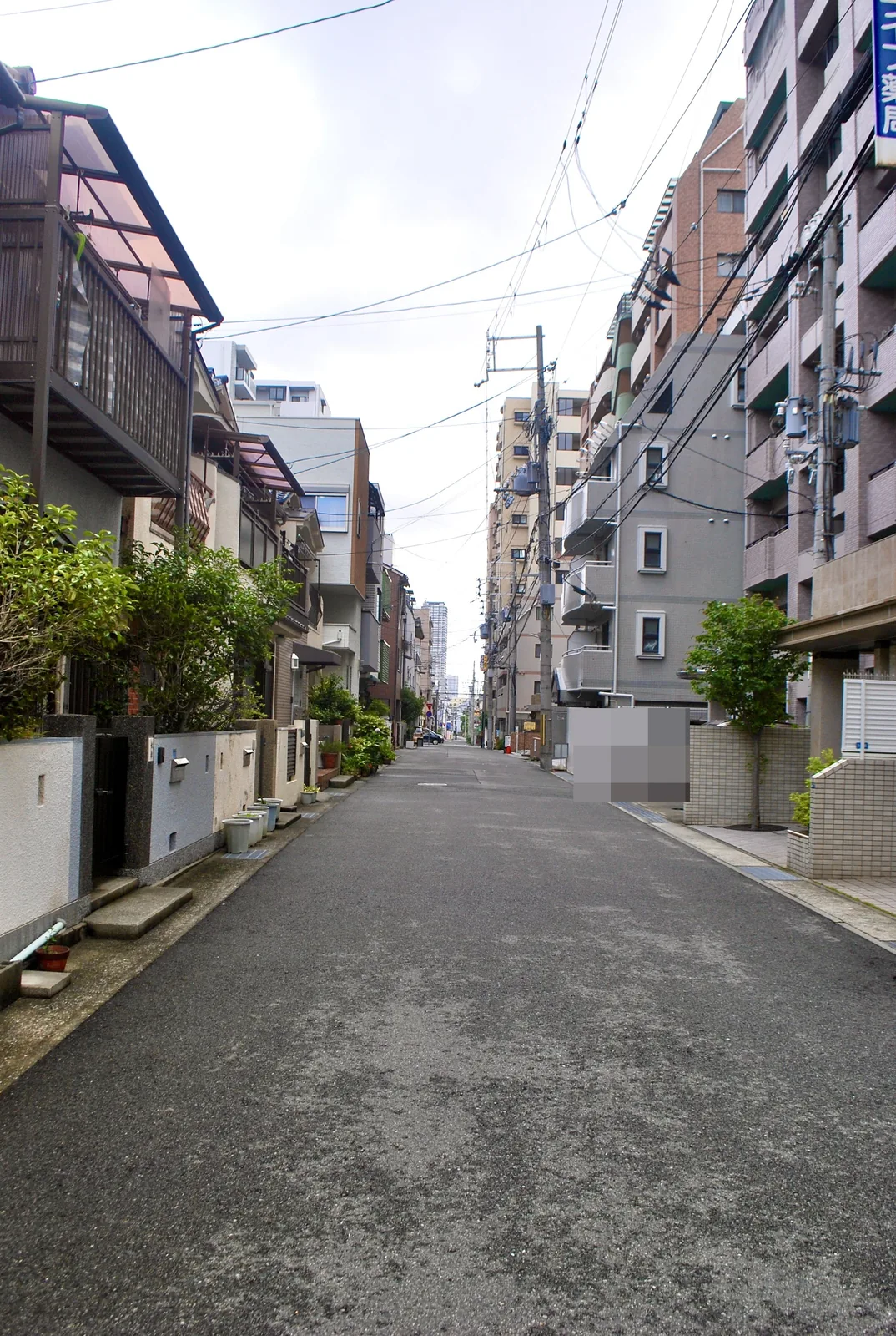 家々とマンションのあいだを、遠くまでまっすぐ続く道